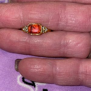 This is a small ring w/a red stone w/ rhinestones on the sides in gold. Size 7